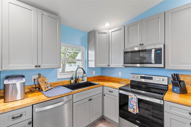 226 Pinegrove Dr, Palm Coast, FL 32164 - kitchen with stainless steel appliances, wood counters, a sink, gray cabinetry, and recessed lighting