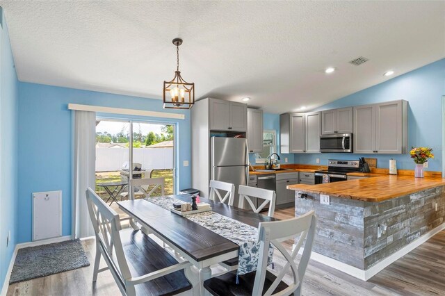 226 Pinegrove Dr, Palm Coast, FL 32164 - dining room featuring a chandelier, light wood-type flooring, a textured ceiling, baseboards, and recessed lighting