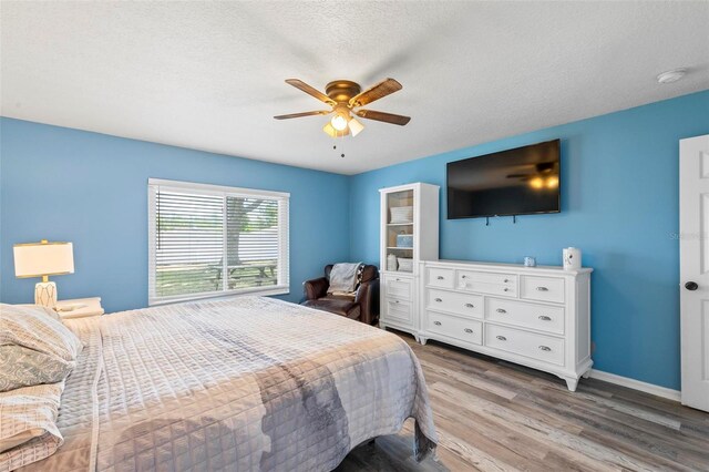 226 Pinegrove Dr, Palm Coast, FL 32164 - bedroom with wood finished floors, baseboards, a ceiling fan, and a textured ceiling
