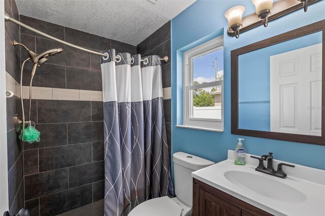 226 Pinegrove Dr, Palm Coast, FL 32164 - full bath with tiled shower, vanity, toilet, and a textured ceiling
