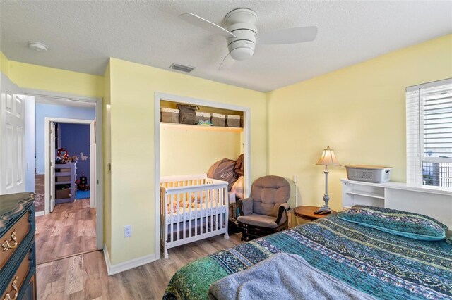 226 Pinegrove Dr, Palm Coast, FL 32164 - bedroom with wood finished floors, a textured ceiling, a ceiling fan, and baseboards