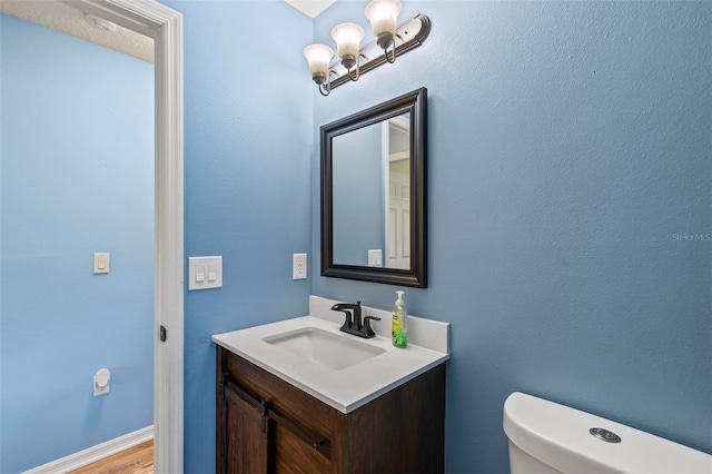 226 Pinegrove Dr, Palm Coast, FL 32164 - half bathroom featuring toilet, vanity, and wood finished floors