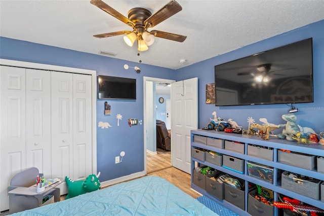226 Pinegrove Dr, Palm Coast, FL 32164 - bedroom with wood finished floors, a closet, ceiling fan, baseboards, and a textured ceiling