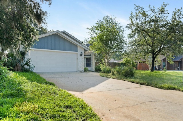 1317 Northside Dr, Ormond Beach, FL 32174 - view of front of house with driveway, a garage, and stone siding