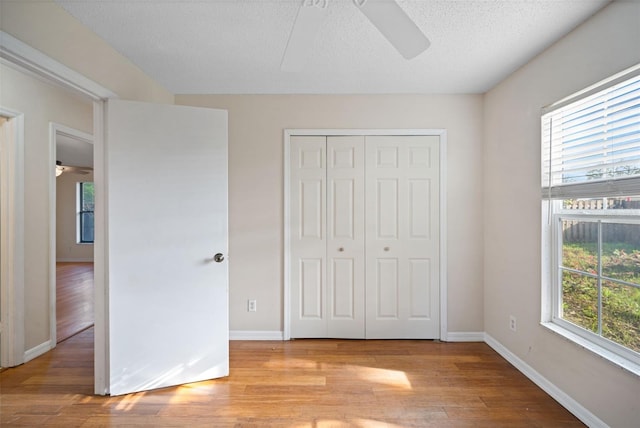 1317 Northside Dr, Ormond Beach, FL 32174 - unfurnished bedroom featuring light wood-type flooring, a closet, ceiling fan, and a textured ceiling