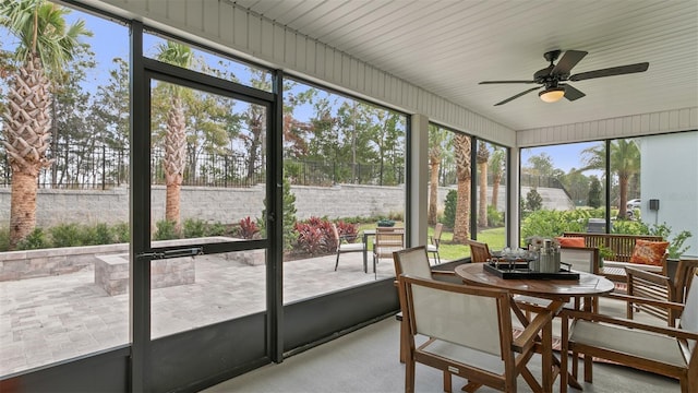 sunroom with ceiling fan, healthy amount of natural light, and outdoor dining space