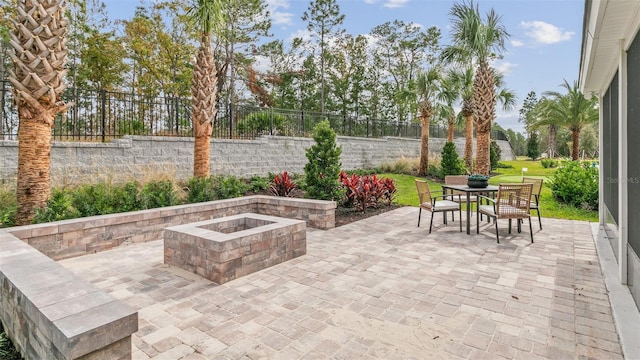 view of patio / terrace featuring a fire pit, outdoor dining area, and a fenced backyard