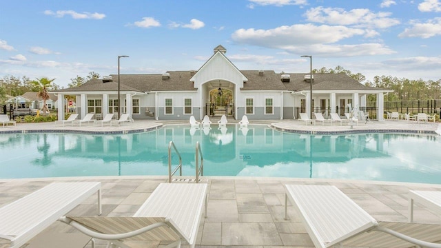 community pool with a patio and fence