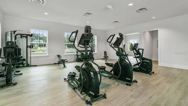 workout area featuring healthy amount of natural light, wood finished floors, baseboards, and recessed lighting