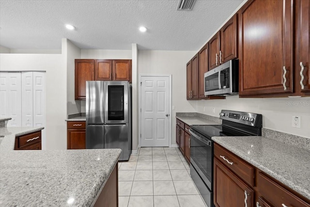 100 Point Pleasant Dr, Palm Coast, FL 32164 - kitchen featuring appliances with stainless steel finishes, light tile patterned floors, and a textured ceiling