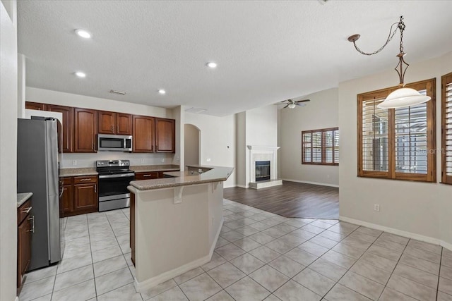 100 Point Pleasant Dr, Palm Coast, FL 32164 - kitchen with stainless steel appliances, light tile patterned floors, a ceiling fan, a tile fireplace, and recessed lighting