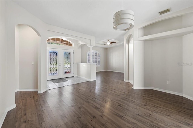 100 Point Pleasant Dr, Palm Coast, FL 32164 - foyer entrance with arched walkways, french doors, wood finished floors, a ceiling fan, and baseboards