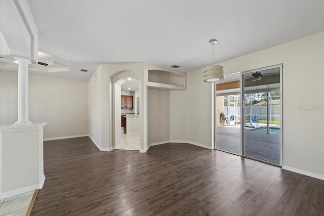 100 Point Pleasant Dr, Palm Coast, FL 32164 - spare room with wood finished floors, baseboards, ornate columns, and a ceiling fan