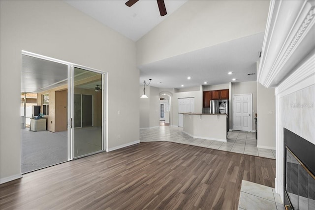 100 Point Pleasant Dr, Palm Coast, FL 32164 - unfurnished living room featuring ceiling fan, light wood finished floors, a tile fireplace, recessed lighting, and arched walkways