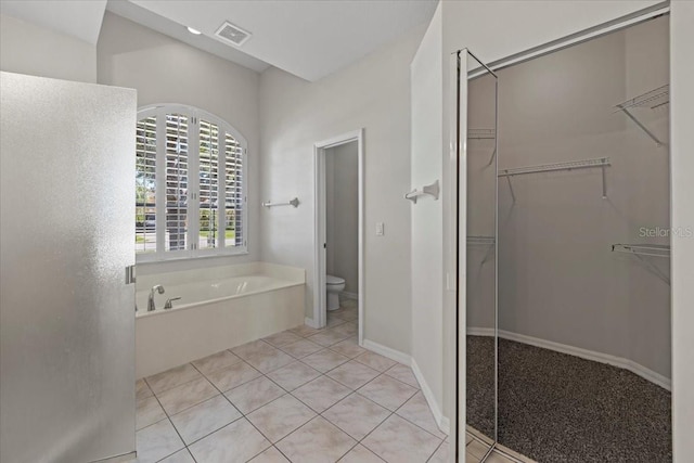 100 Point Pleasant Dr, Palm Coast, FL 32164 - full bath with a garden tub, toilet, a walk in closet, and tile patterned floors