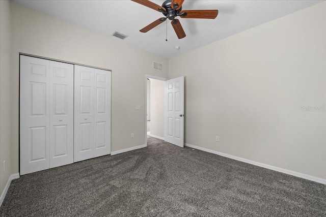 100 Point Pleasant Dr, Palm Coast, FL 32164 - unfurnished bedroom with dark colored carpet, a closet, baseboards, and a ceiling fan