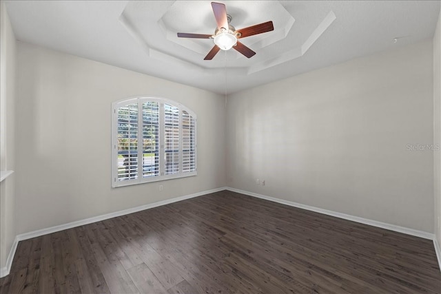 100 Point Pleasant Dr, Palm Coast, FL 32164 - spare room featuring a raised ceiling, dark wood-style floors, ceiling fan, and baseboards