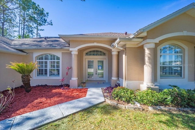100 Point Pleasant Dr, Palm Coast, FL 32164 - property entrance featuring french doors, roof with shingles, and stucco siding
