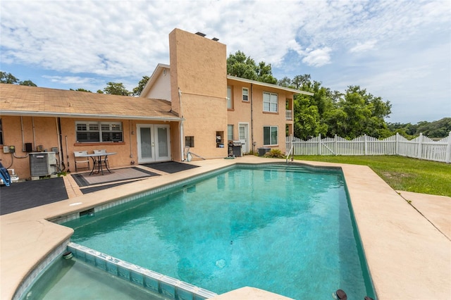 5009 Shore Dr, Saint Augustine, FL 32086 - view of swimming pool featuring french doors, a patio area, central AC unit, area for grilling, and a pool with connected hot tub