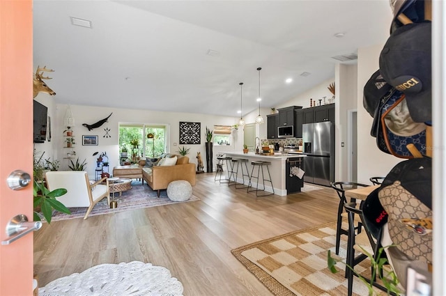 40 Biscayne Dr, Palm Coast, FL 32137 - living area featuring vaulted ceiling and light wood-style floors