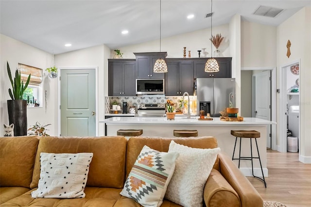 40 Biscayne Dr, Palm Coast, FL 32137 - kitchen featuring appliances with stainless steel finishes, open floor plan, light countertops, a sink, and vaulted ceiling