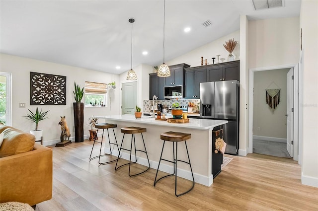 40 Biscayne Dr, Palm Coast, FL 32137 - kitchen with appliances with stainless steel finishes, a kitchen breakfast bar, light countertops, decorative backsplash, and a kitchen island with sink