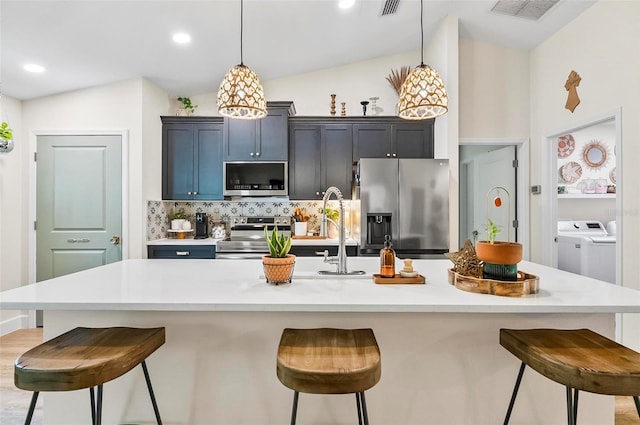40 Biscayne Dr, Palm Coast, FL 32137 - kitchen with stainless steel appliances, a kitchen bar, tasteful backsplash, vaulted ceiling, and light countertops