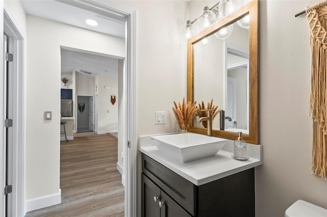 40 Biscayne Dr, Palm Coast, FL 32137 - half bathroom with vanity, toilet, wood finished floors, and baseboards