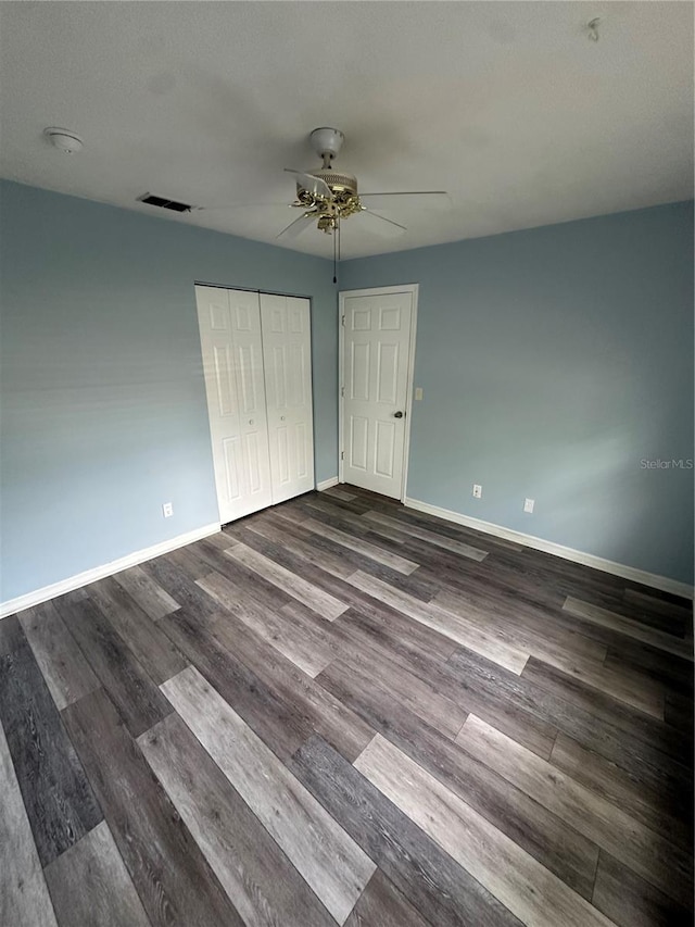 4 Sleepy Hollow Trl, Palm Coast, FL 32164 - unfurnished bedroom featuring dark wood finished floors, baseboards, a closet, and ceiling fan