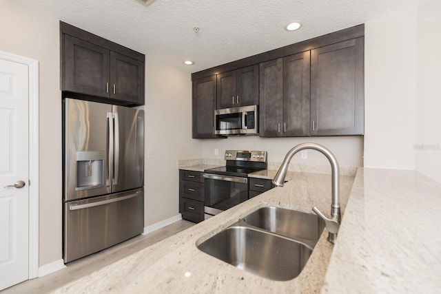 600 Canopy Walk Ln Unit 634, Palm Coast, FL 32137 - kitchen with appliances with stainless steel finishes, a sink, light stone countertops, dark brown cabinets, and recessed lighting
