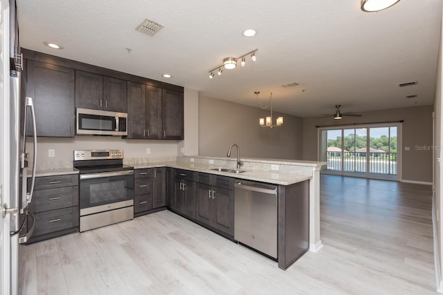 600 Canopy Walk Ln Unit 634, Palm Coast, FL 32137 - kitchen with stainless steel appliances, a sink, a peninsula, a ceiling fan, and light wood-type flooring