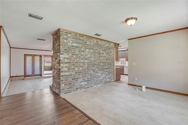 1466 Arena Rd, Fleming Island, FL 32003 - empty room with ornamental molding, light wood-style floors, baseboards, a textured ceiling, and french doors