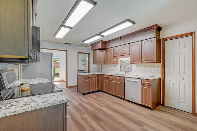 1466 Arena Rd, Fleming Island, FL 32003 - kitchen featuring dishwasher, a sink, light wood-type flooring, and backsplash