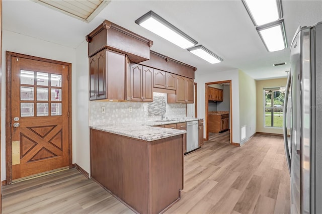 1466 Arena Rd, Fleming Island, FL 32003 - kitchen featuring appliances with stainless steel finishes, a peninsula, backsplash, light wood-type flooring, and a sink