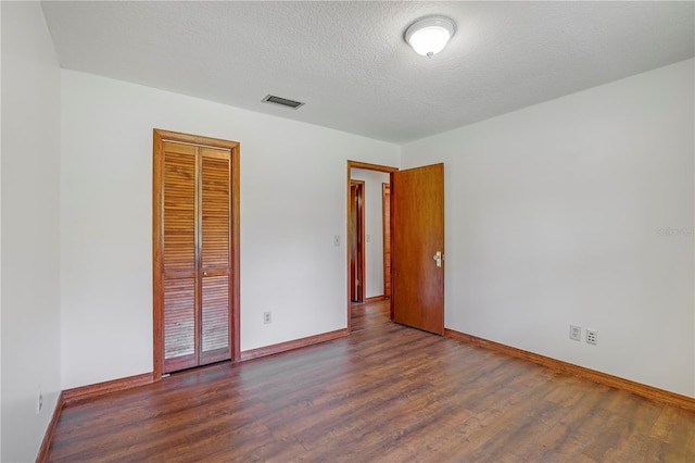 1466 Arena Rd, Fleming Island, FL 32003 - unfurnished bedroom with baseboards, wood finished floors, a closet, and a textured ceiling
