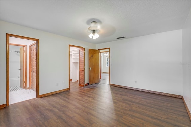 1466 Arena Rd, Fleming Island, FL 32003 - unfurnished bedroom with baseboards, wood finished floors, and a walk in closet