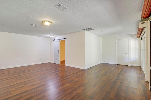 1466 Arena Rd, Fleming Island, FL 32003 - unfurnished room featuring dark wood finished floors, a barn door, a textured ceiling, and baseboards