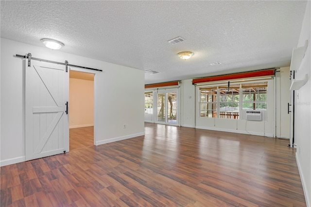 1466 Arena Rd, Fleming Island, FL 32003 - unfurnished living room featuring a barn door, wood finished floors, a textured ceiling, and baseboards