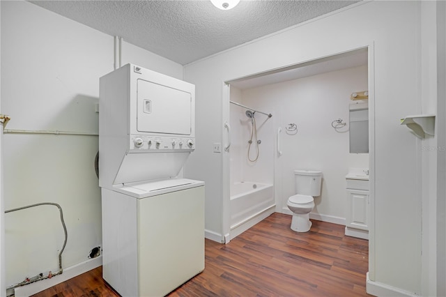 1466 Arena Rd, Fleming Island, FL 32003 - laundry room with stacked washing machine and dryer, a textured ceiling, and dark wood-type flooring