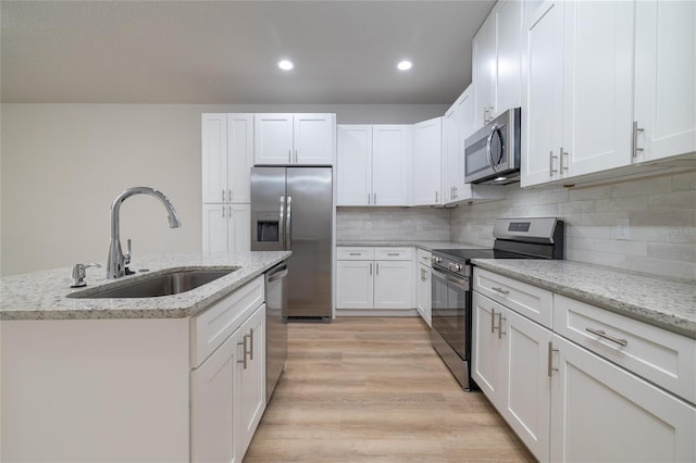 47 Providence Ln, Palm Coast, FL 32164 - kitchen featuring stainless steel appliances, a sink, white cabinetry, recessed lighting, and light wood-type flooring