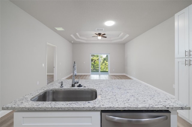47 Providence Ln, Palm Coast, FL 32164 - kitchen featuring dishwasher, a sink, open floor plan, a raised ceiling, and light wood-style flooring