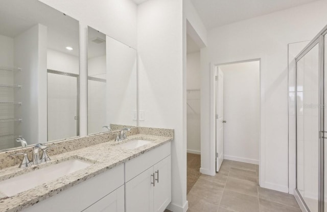 9 Wandering Crk, Way, Palm Coast, FL 32164 - full bathroom with a walk in closet, double vanity, a shower stall, and baseboards