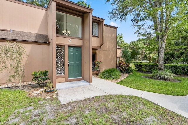 8 Oakmont Ct Unit 0, Palm Coast, FL 32137 - entrance to property with stucco siding and a lawn