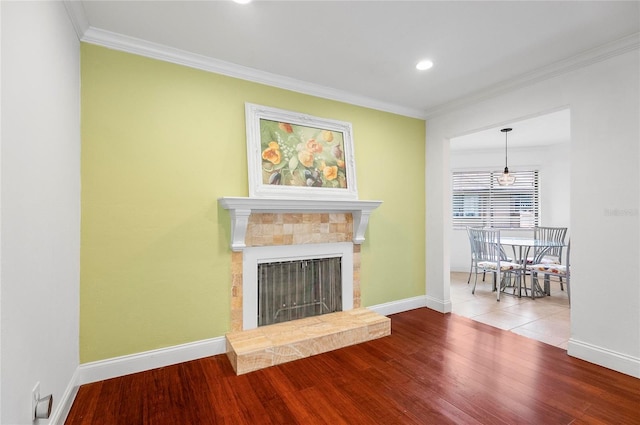 8 Oakmont Ct Unit 0, Palm Coast, FL 32137 - living room featuring ornamental molding, wood finished floors, baseboards, a tiled fireplace, and recessed lighting