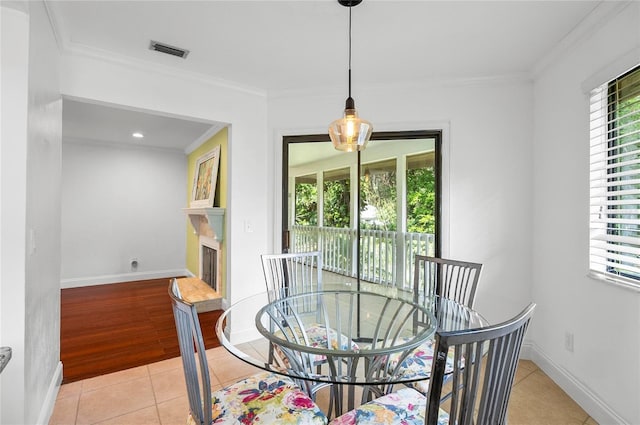 8 Oakmont Ct Unit 0, Palm Coast, FL 32137 - dining area featuring crown molding, light tile patterned floors, baseboards, and a fireplace with raised hearth