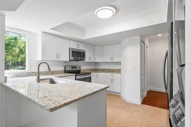 8 Oakmont Ct Unit 0, Palm Coast, FL 32137 - kitchen featuring stainless steel appliances, a sink, ornamental molding, a tray ceiling, and a peninsula