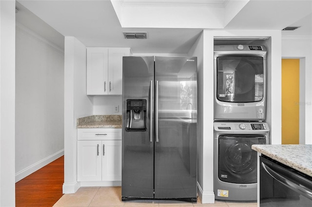 8 Oakmont Ct Unit 0, Palm Coast, FL 32137 - laundry room featuring stacked washing machine and dryer, crown molding, baseboards, and light wood finished floors
