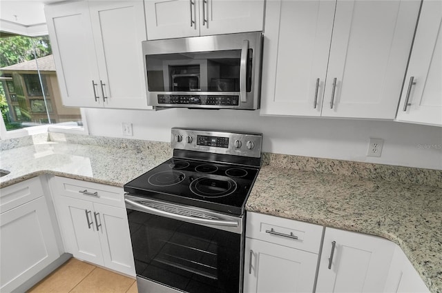 8 Oakmont Ct Unit 0, Palm Coast, FL 32137 - kitchen with appliances with stainless steel finishes, white cabinetry, light stone countertops, and light tile patterned flooring