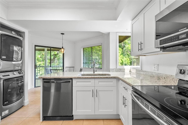 8 Oakmont Ct Unit 0, Palm Coast, FL 32137 - kitchen featuring stainless steel appliances, a sink, stacked washer / drying machine, white cabinetry, and ornamental molding
