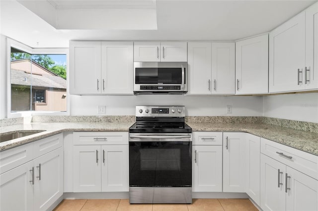 8 Oakmont Ct Unit 0, Palm Coast, FL 32137 - kitchen featuring stainless steel appliances, white cabinets, light tile patterned flooring, light stone countertops, and a sink